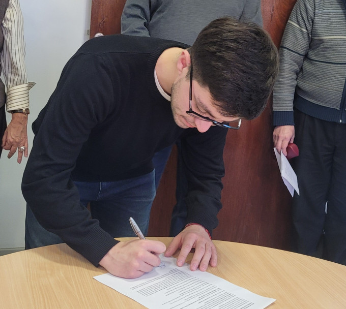 imagen Momento de la firma de las/los representantes.